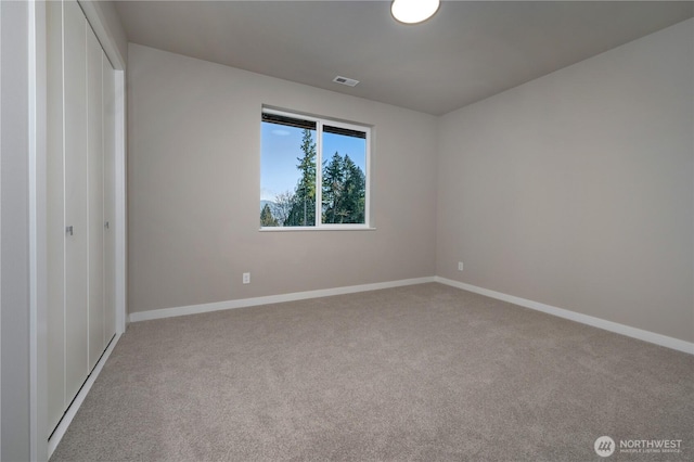 unfurnished bedroom with carpet floors, a closet, visible vents, and baseboards