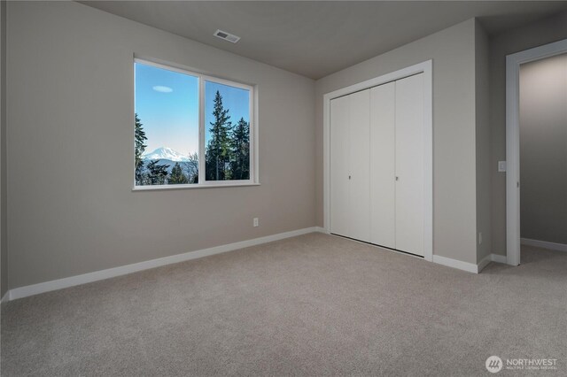 unfurnished bedroom with a closet, baseboards, visible vents, and carpet flooring