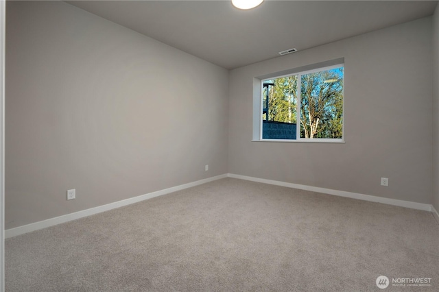 carpeted spare room featuring baseboards and visible vents