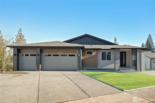 view of front of property with a garage, a front yard, concrete driveway, and board and batten siding