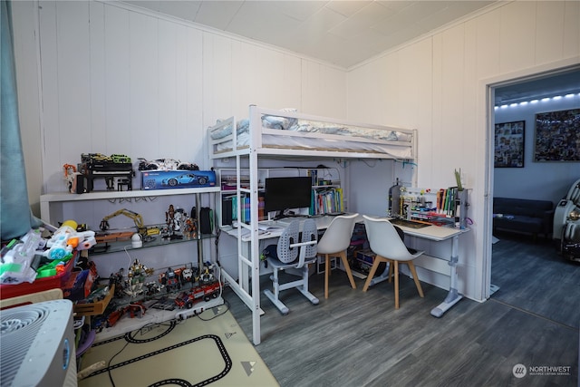 bedroom featuring dark wood-type flooring and wooden walls