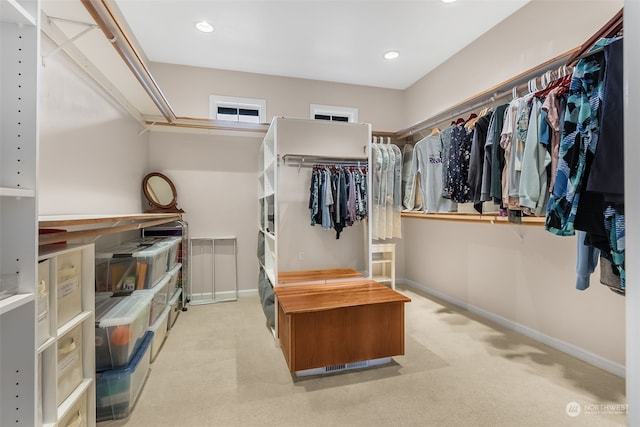 walk in closet featuring light colored carpet