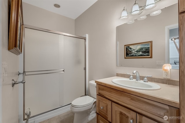 bathroom with a shower with door, toilet, vanity, and tile patterned floors