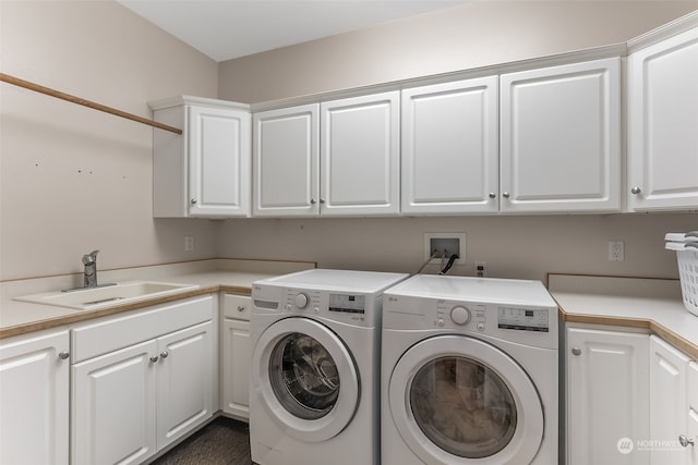 washroom with sink, washing machine and dryer, and cabinets