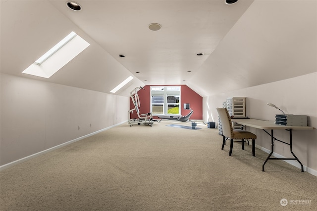 carpeted home office with vaulted ceiling with skylight