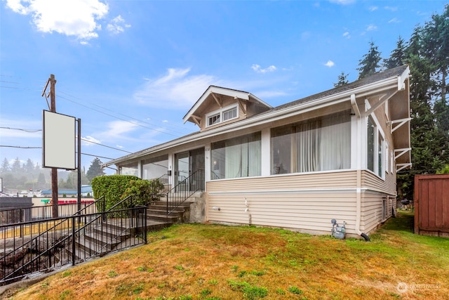 view of front of home featuring a front lawn and a sunroom