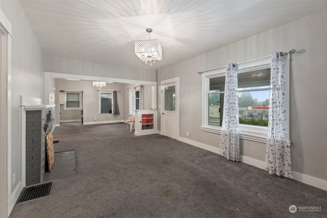 unfurnished living room with dark carpet and a fireplace