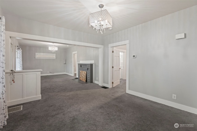 unfurnished living room featuring dark carpet, a chandelier, and a fireplace