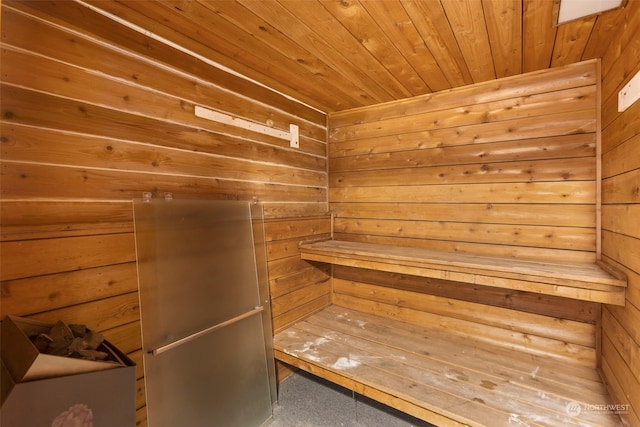 view of sauna featuring wood ceiling and wood walls