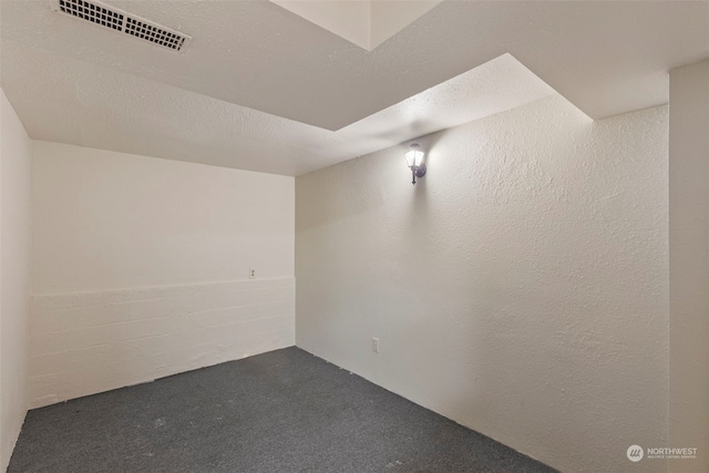 carpeted empty room with a textured ceiling