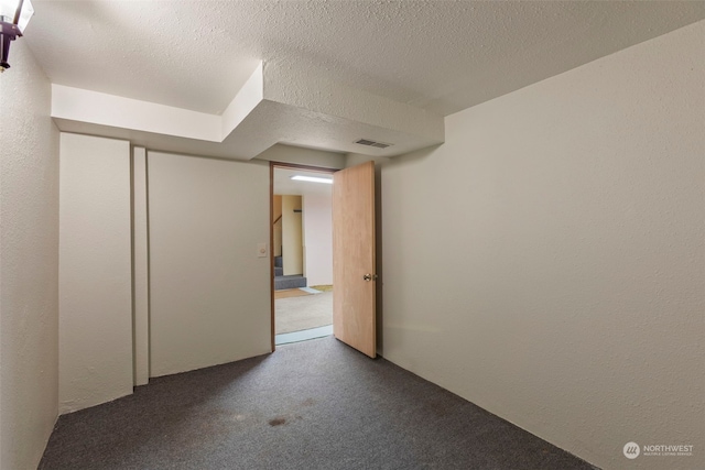 unfurnished room featuring a textured ceiling and carpet floors