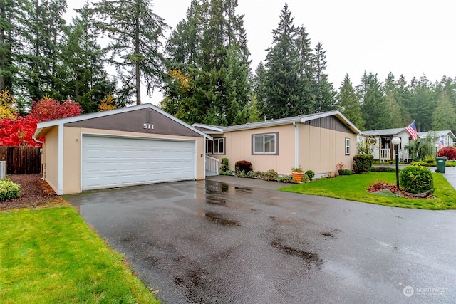 ranch-style house with a garage and a front lawn