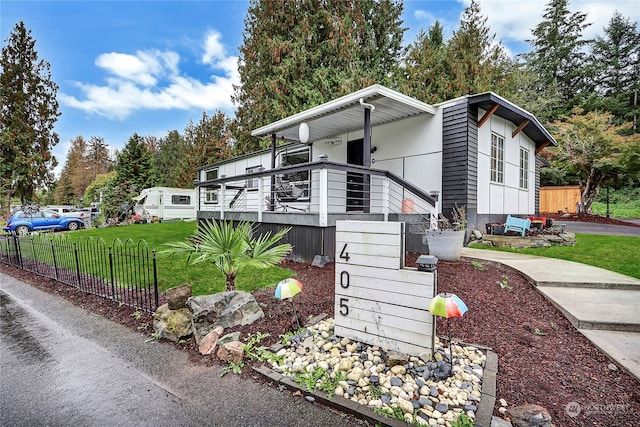 view of front facade featuring a front lawn and a wooden deck