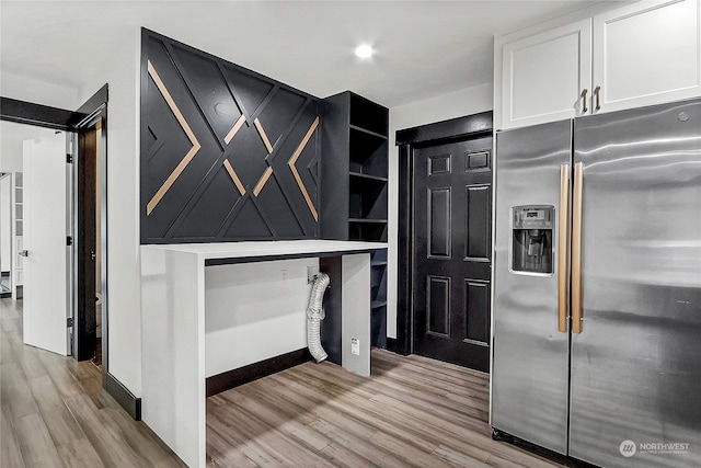 kitchen with white cabinetry, light hardwood / wood-style floors, and stainless steel fridge with ice dispenser