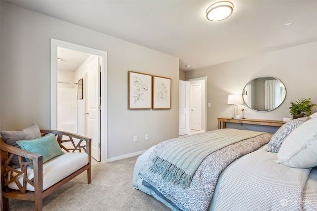 bedroom featuring ensuite bath and light colored carpet