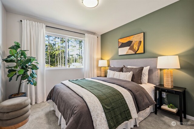 carpeted bedroom with lofted ceiling