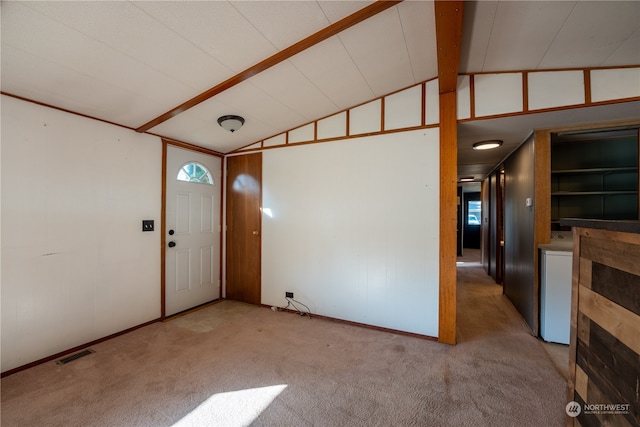 carpeted foyer with lofted ceiling with beams