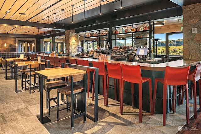 bar featuring a mountain view and wooden ceiling