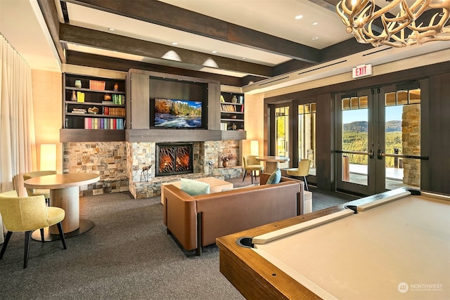 playroom with french doors, dark colored carpet, beam ceiling, built in features, and a fireplace