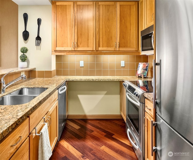 kitchen featuring dark wood-type flooring, sink, light stone countertops, appliances with stainless steel finishes, and tasteful backsplash