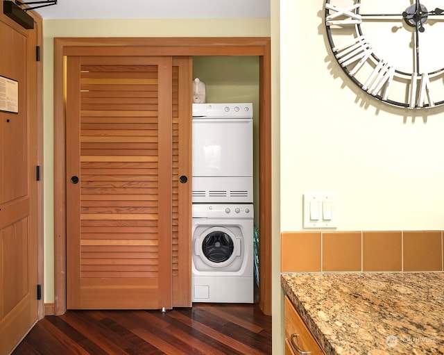 washroom featuring stacked washer and dryer and dark hardwood / wood-style flooring