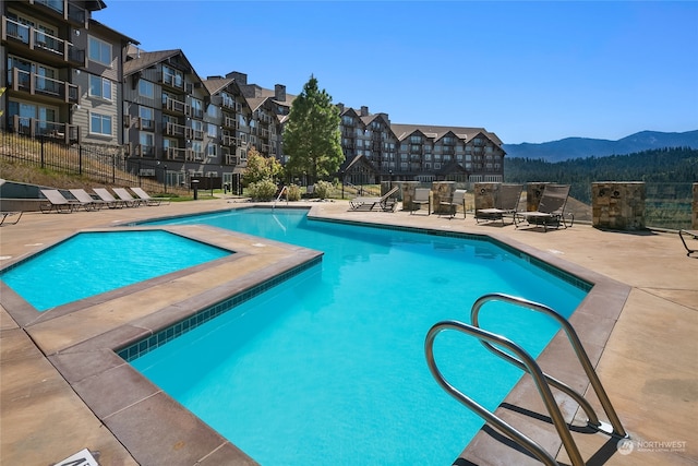 view of swimming pool featuring a patio and a mountain view