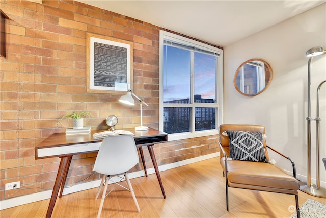 office featuring light hardwood / wood-style floors and brick wall