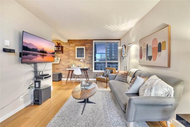 living room with brick wall and wood-type flooring