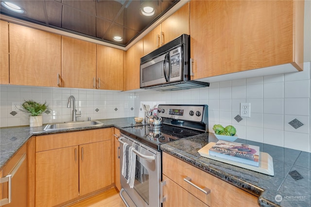 kitchen featuring sink, electric range, dark stone countertops, decorative backsplash, and light hardwood / wood-style flooring