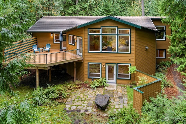 rear view of property featuring a wooden deck