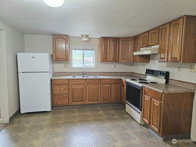 kitchen featuring a textured ceiling, sink, and white appliances