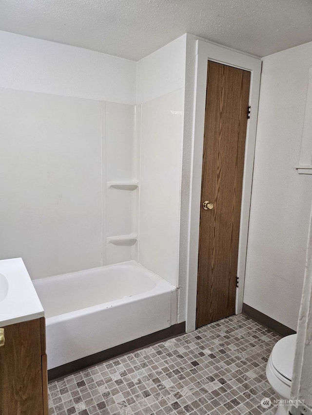 bathroom with vanity, a textured ceiling, and toilet