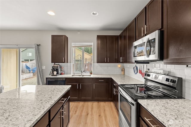 kitchen featuring sink, appliances with stainless steel finishes, light hardwood / wood-style flooring, and backsplash