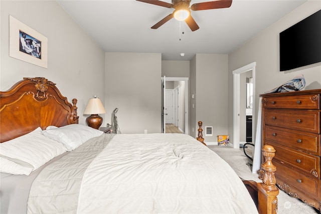 bedroom with ensuite bath, light carpet, and ceiling fan