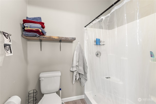 bathroom featuring wood-type flooring, a shower with curtain, and toilet