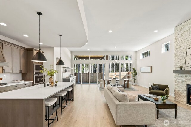 6361LOT257 Great Glen Rd SW, Port Orchard, WA 98367 - living area featuring light wood-type flooring, recessed lighting, baseboards, and a stone fireplace