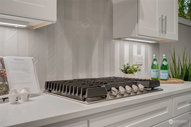 room details featuring stainless steel gas cooktop and white cabinets