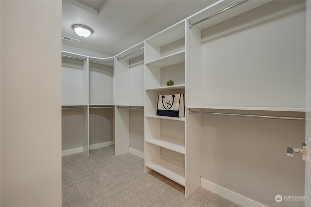 walk in closet featuring light carpet