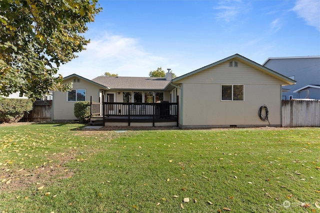 back of property featuring a deck and a lawn