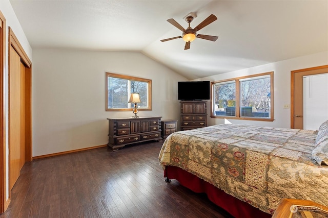 bedroom with dark hardwood / wood-style flooring, vaulted ceiling, a closet, and ceiling fan