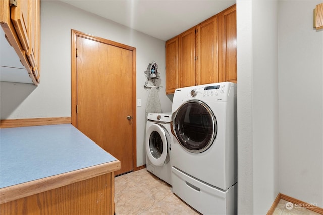 laundry room featuring washer and dryer and cabinets