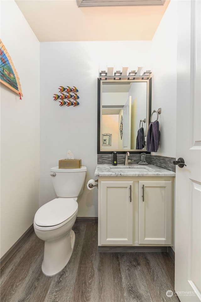 bathroom featuring vanity, hardwood / wood-style flooring, and toilet