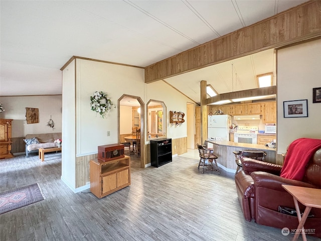 living room featuring lofted ceiling, wooden walls, and wood-type flooring