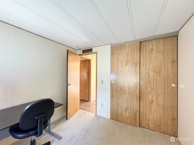 office area featuring a textured ceiling and light colored carpet