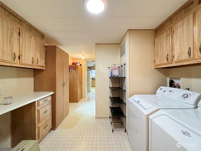 laundry room featuring washing machine and dryer and cabinets