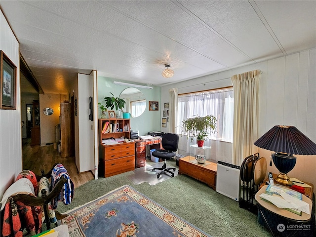 office area with wood walls, hardwood / wood-style floors, and a textured ceiling