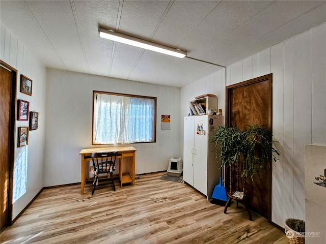 misc room with wooden walls and light wood-type flooring