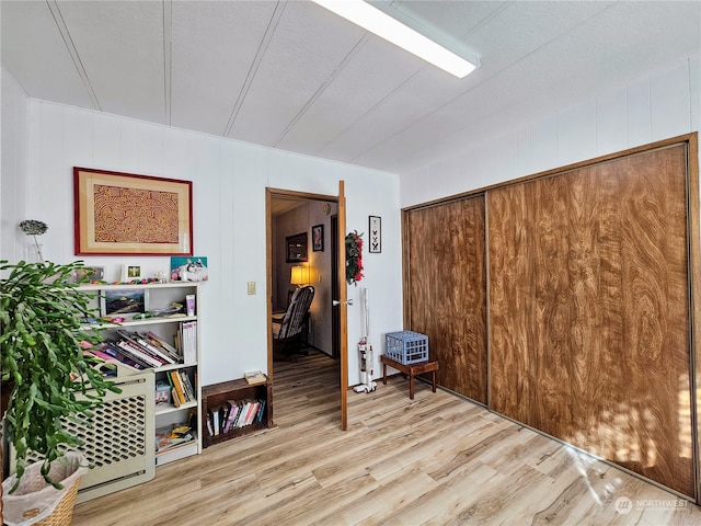 misc room with hardwood / wood-style floors and wood walls