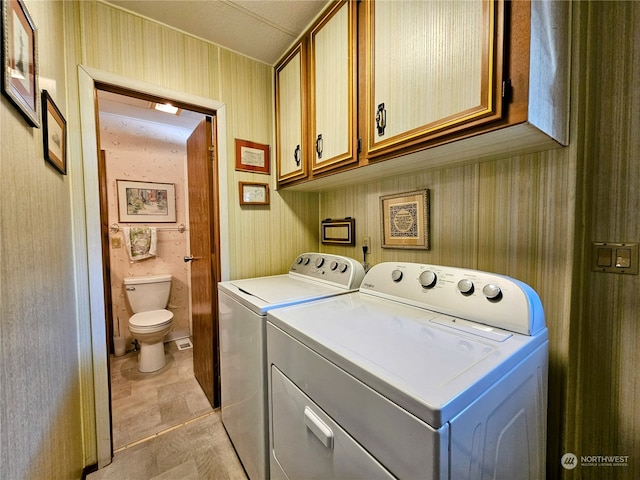 laundry area featuring washer and dryer and cabinets