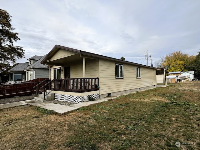 rear view of property featuring a wooden deck and a yard